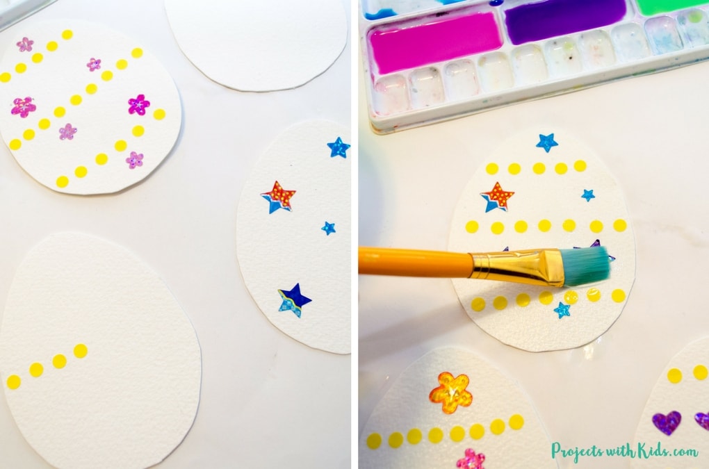 Use stickers to create this gorgeous watercolor easter egg art with kids. Easy watercolor techniques that produce amazing results. So simple and fun for kids of all ages! Free printable easter egg template included. 