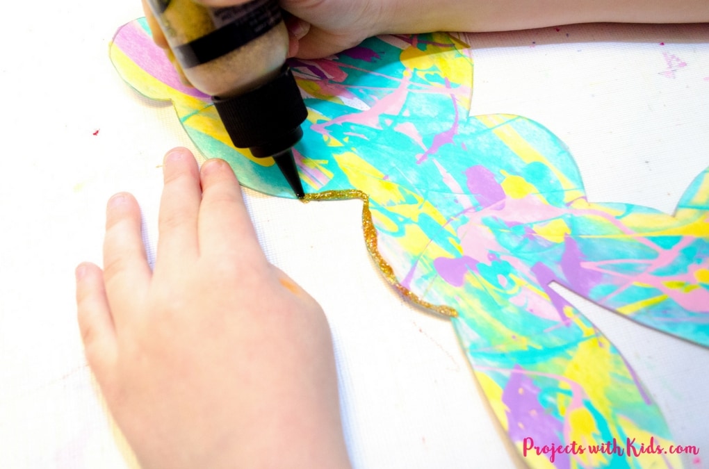 Scrape painting is a super fun process art activity that kids will love! Use beautiful spring colors to make these bunny silhouettes that are the perfect art project for spring or Easter. Edge them in gold glitter for an extra special touch! A great project for preschool aged kids and beyond. Free printable bunny template included. 