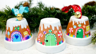 Transform mini terra cotta pots into the sweetest gingerbread house ornaments! Kids will love making this adorable Christmas craft to hang on the tree or give as a special gift.