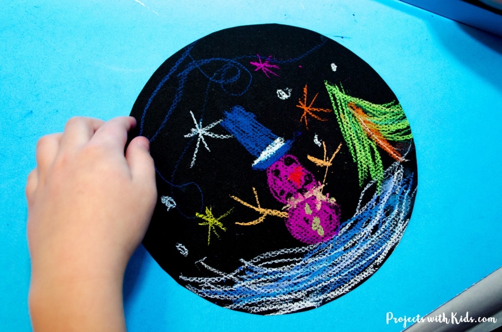 Brighten up your winter with this colorful snowglobe craft. Chalk pastels on black paper help make these snow globes extra vivid. Kids will love creating their own winter wonderland scene and exploring chalk pastels! Free printable template included. 
