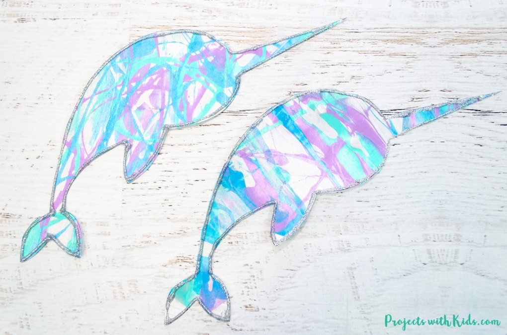 This winter scrape painting activity is a fun and super easy process art project that kids in preschool and beyond will love! Use icy winter colors to make this narwhal craft and edge them in silver glitter for an extra special touch. Free narwhal printable template included.
