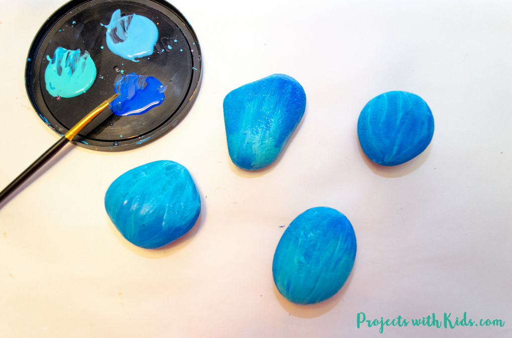 Easy steps for how to draw mermaid scales on painted rocks. A fun rock painting activity for kids that would be perfect for playdates, birthday parties, summer camps or any time! 