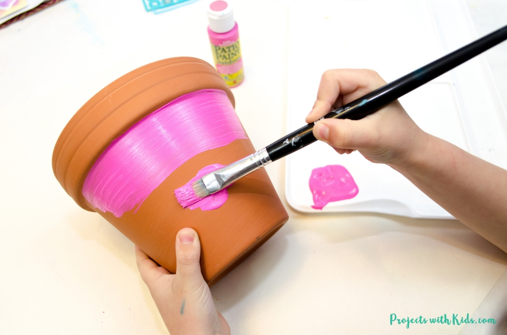 These bright and cheerful DIY painted flower pots are so fun and easy for kids to make! A wonderful kid-made gift idea for Mother's Day, and a great summer craft project. 