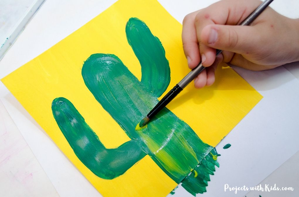 Adding light green to a cactus painting.