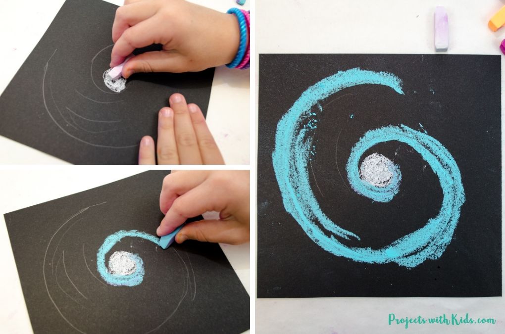 Drawing a galaxy spiral with white and blue chalk pastels