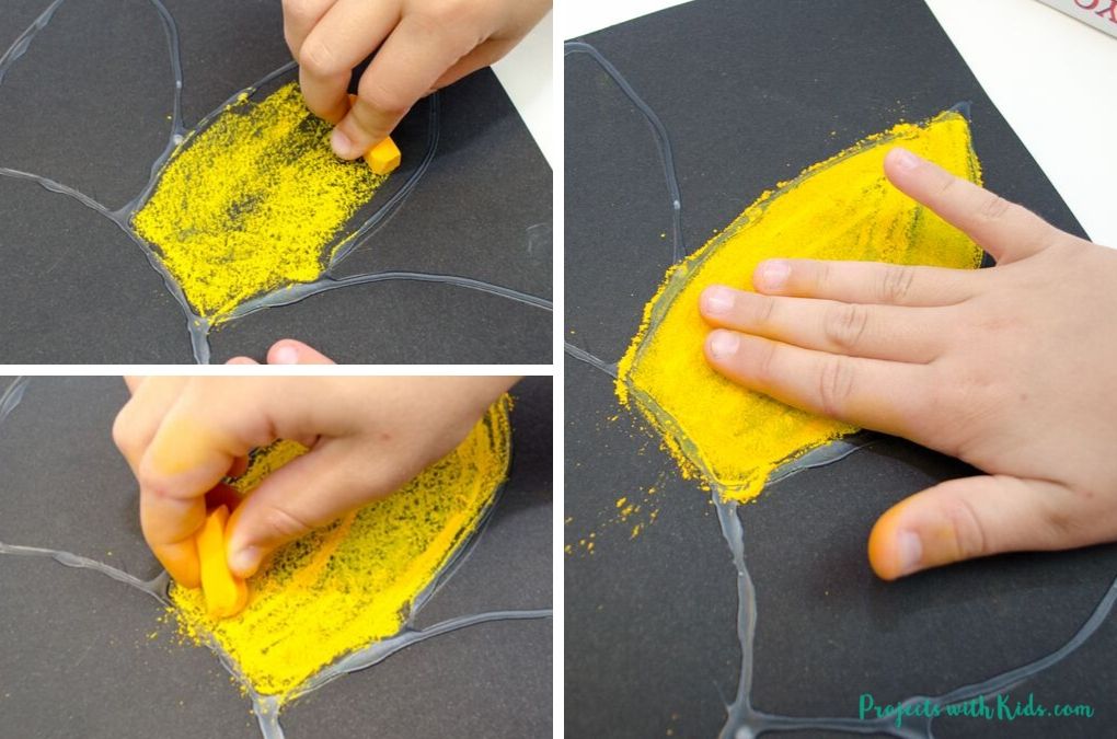 Drawing sunflower petals with yellow and orange chalk pastels.