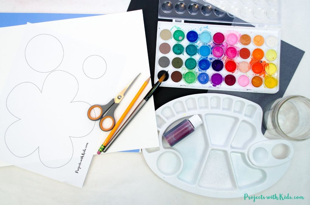 Poppy template, watercolor paints, paint palette, scissors, glue stick, pencil, paintbrush, watercolor paper, black and grey cardstock.