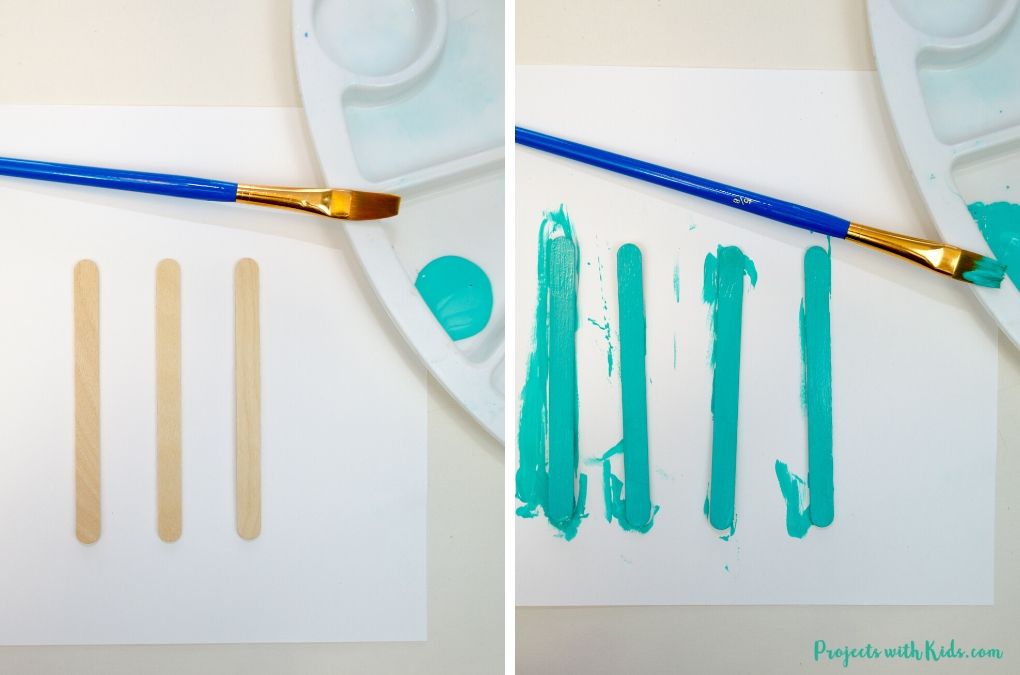 Painting four popsicle sticks a turquoise blue