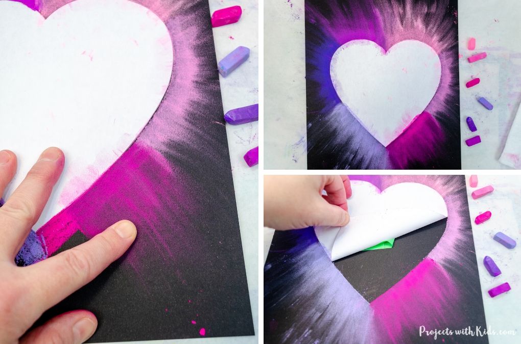 Smudging pastels around a heart template for a Valentine's Day art project.