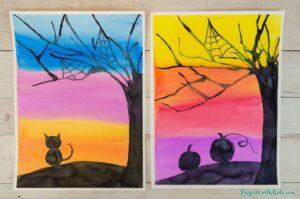 Halloween silhouette art project for kids using watercolors and blow painting with straws