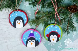 DIY penguin ornaments using wood slices and acrylic paint
