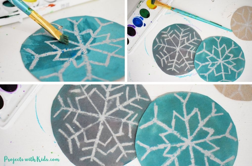 Painting watercolor on cardboard circles to make Christmas ornaments