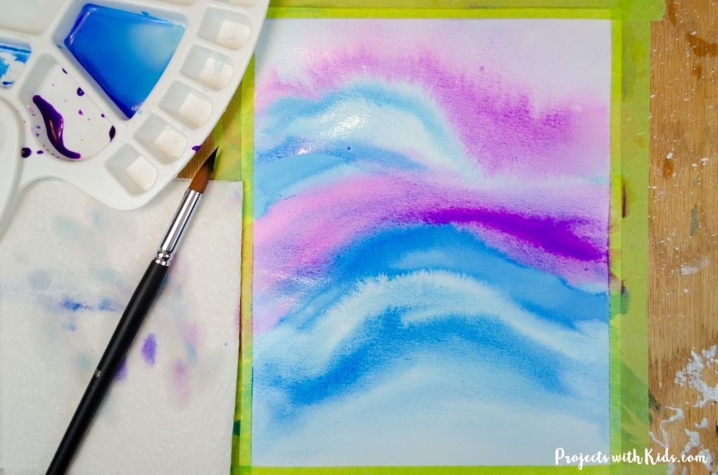 Painting with watercolor using a wet on wet technique to create a winter sky.