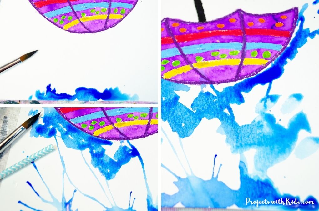 Blow painting rain with watercolor paint and a straw spring art project for kids to make.