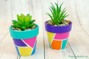 painted flower pots with geometric design for spring or summer kids craft idea.
