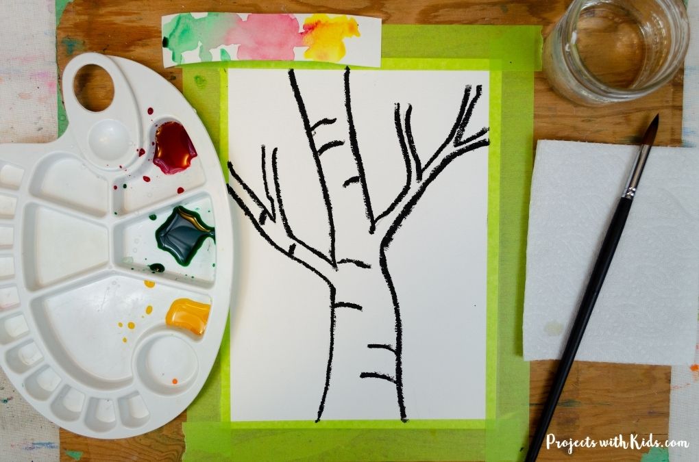 Mixing watercolors in a palette for a fall tree painting