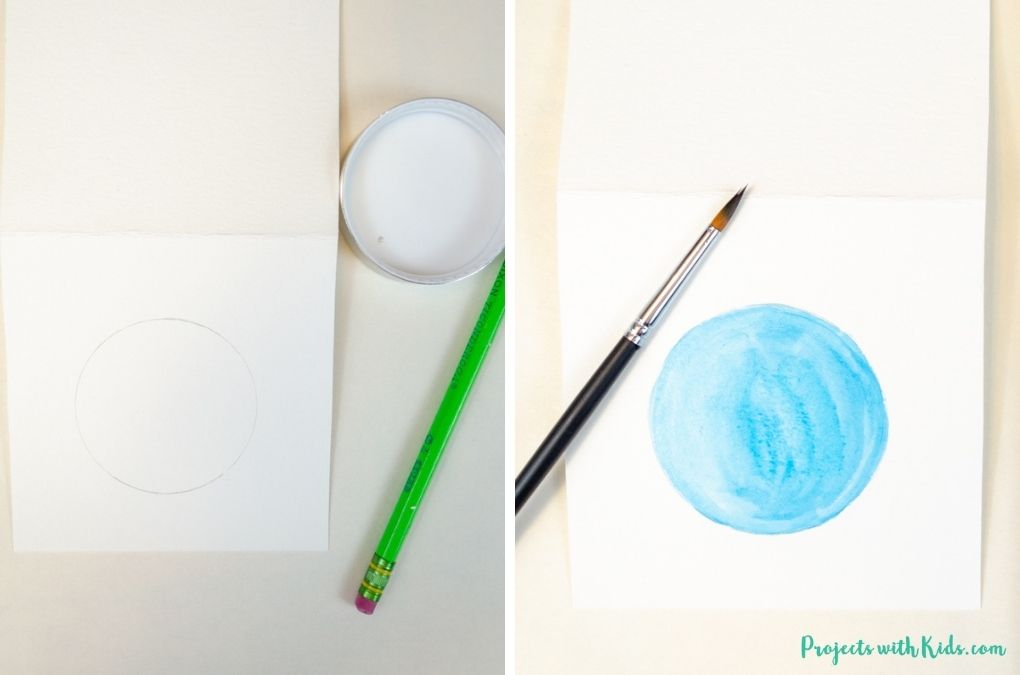 drawing a circle and painting it blue with watercolor paint.