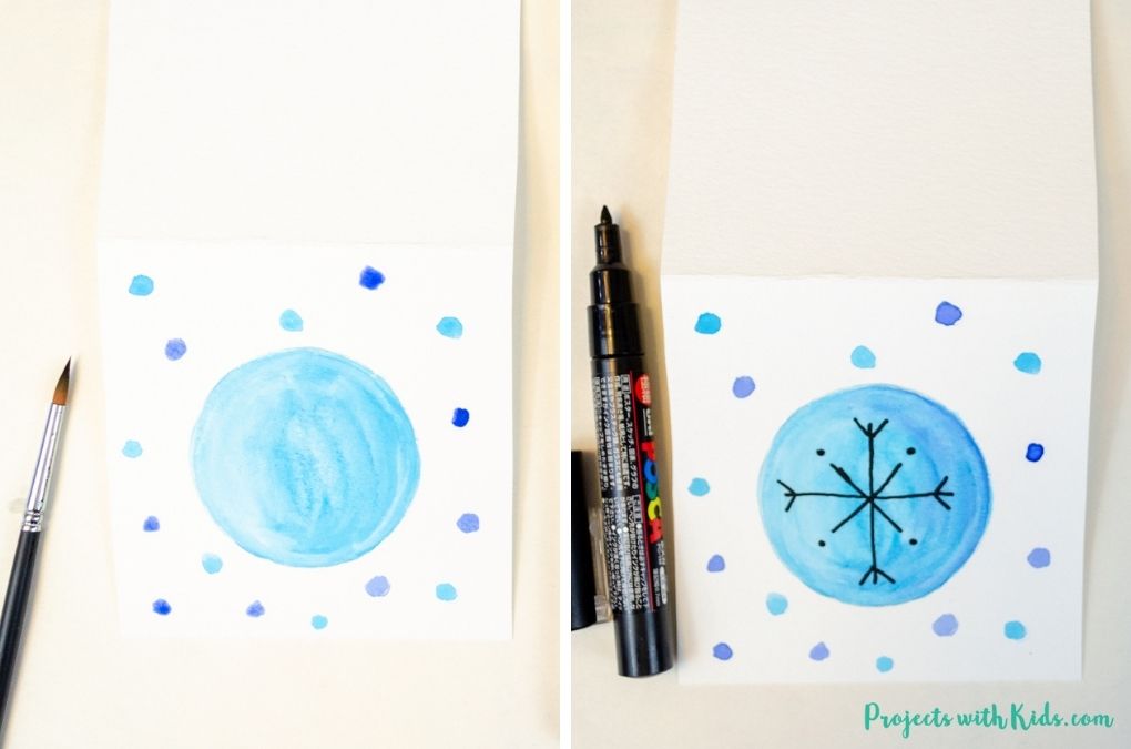 Drawing a snowflake design on a blue painted circle
