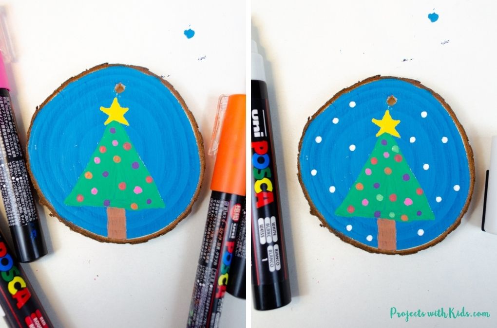 Using paint pens to decorate a wood slice ornament