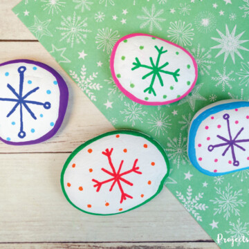 Colorful snowflake painted rocks winter project idea for kids