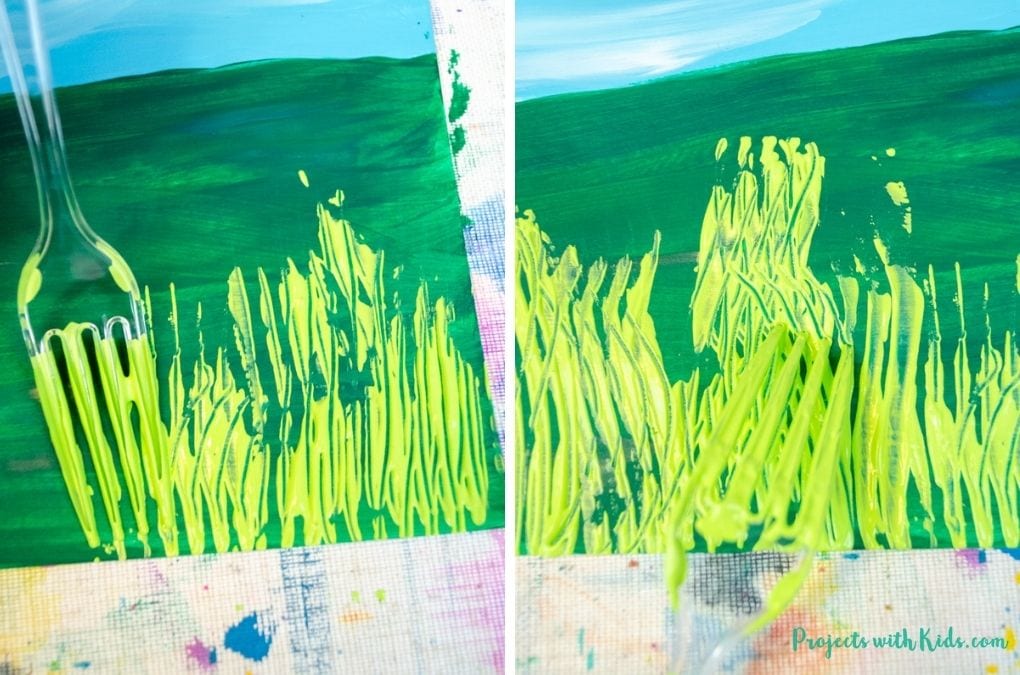 Using a fork to paint grass with green acrylic paint