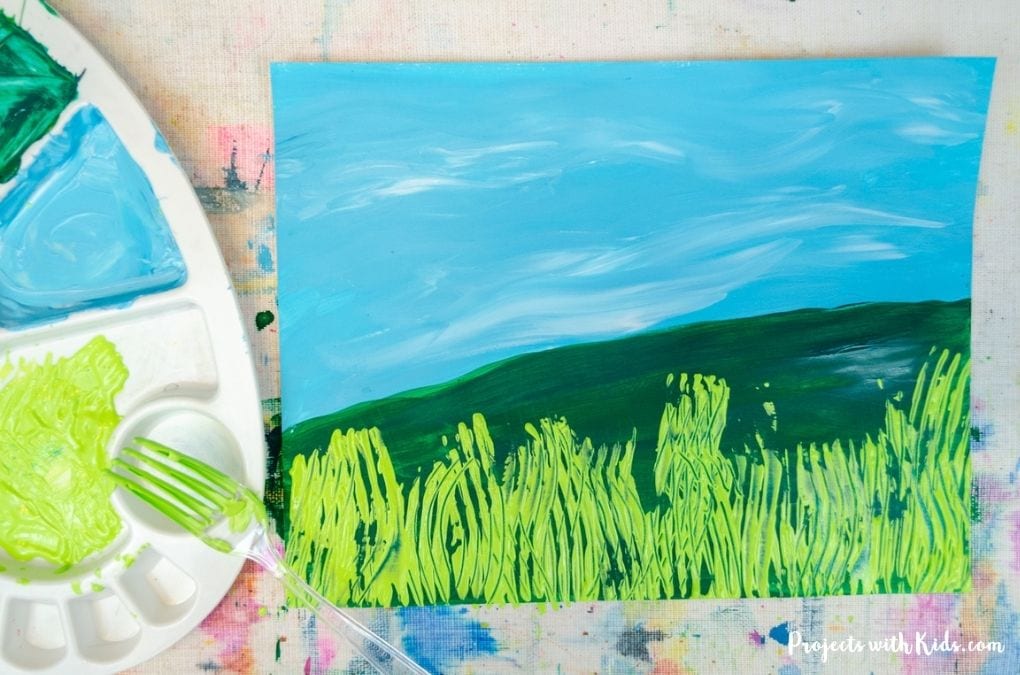 Using a fork to paint grass.