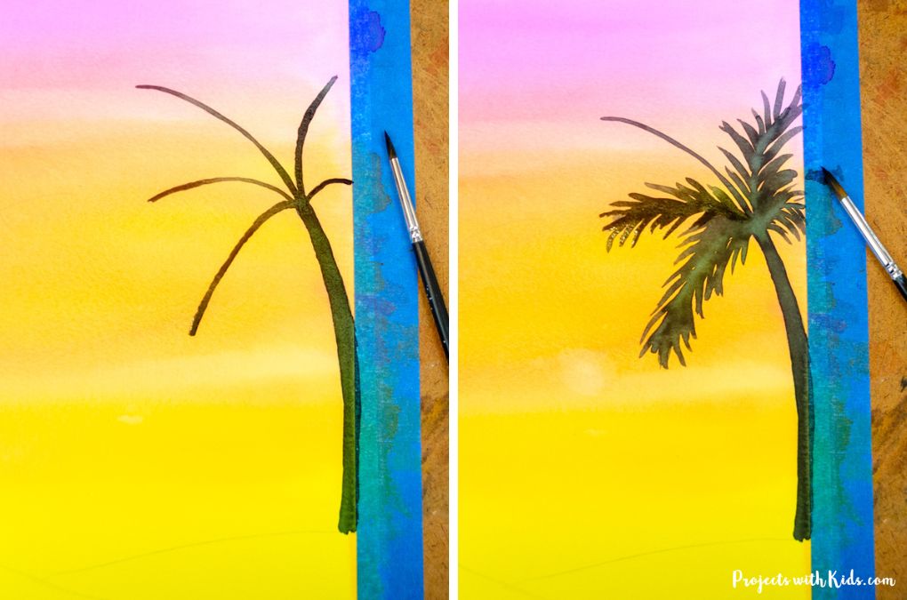 Starting to paint palm tree silhouettes against a watercolor sunset sky.