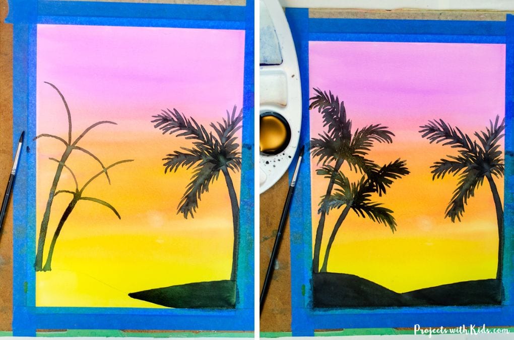 Painting palm trees with black watercolor paint against a sunset watercolor sky.