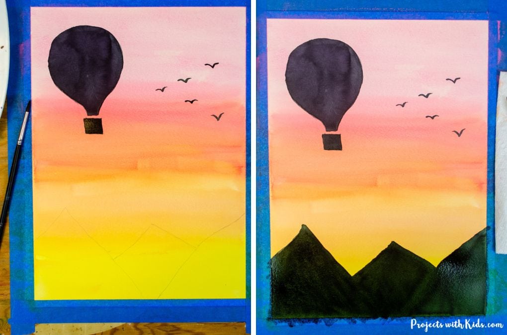 Hot air balloon and mountains silhouettes painted against a yellow, orange and red watercolor sunset.