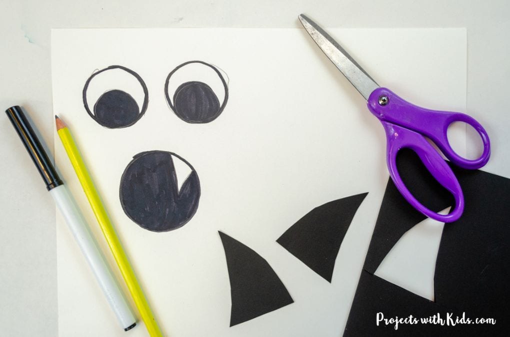 Drawing and cutting out eyes, mouth and horn for a sponge painted monster art project