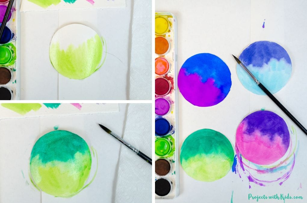 Painting a green sky on watercolor paper for a Christmas ornament craft idea for kids