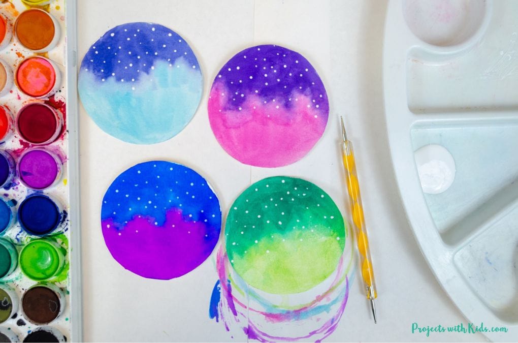 Using a doting tool to paint on stars to watercolor Christmas ornaments