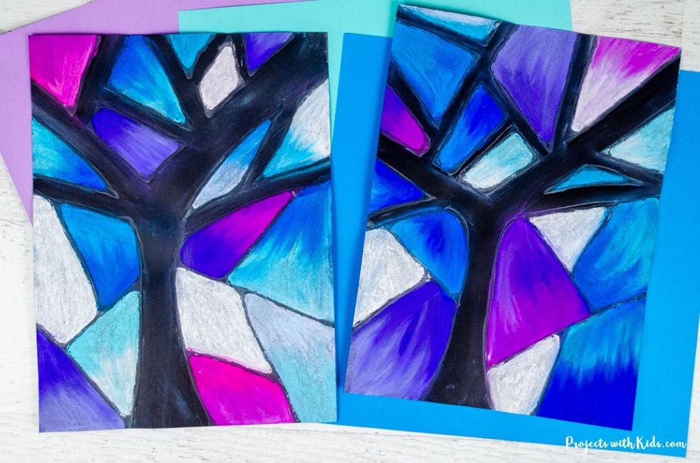 2 examples of a winter tree art project for kids using chalk pastels in shades of blue and purple on black paper using a glue resist technique. 