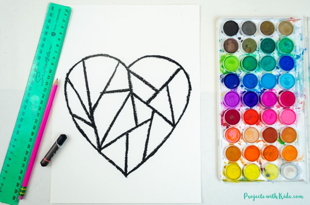Drawing geometric shapes inside a heart on watercolor paper.