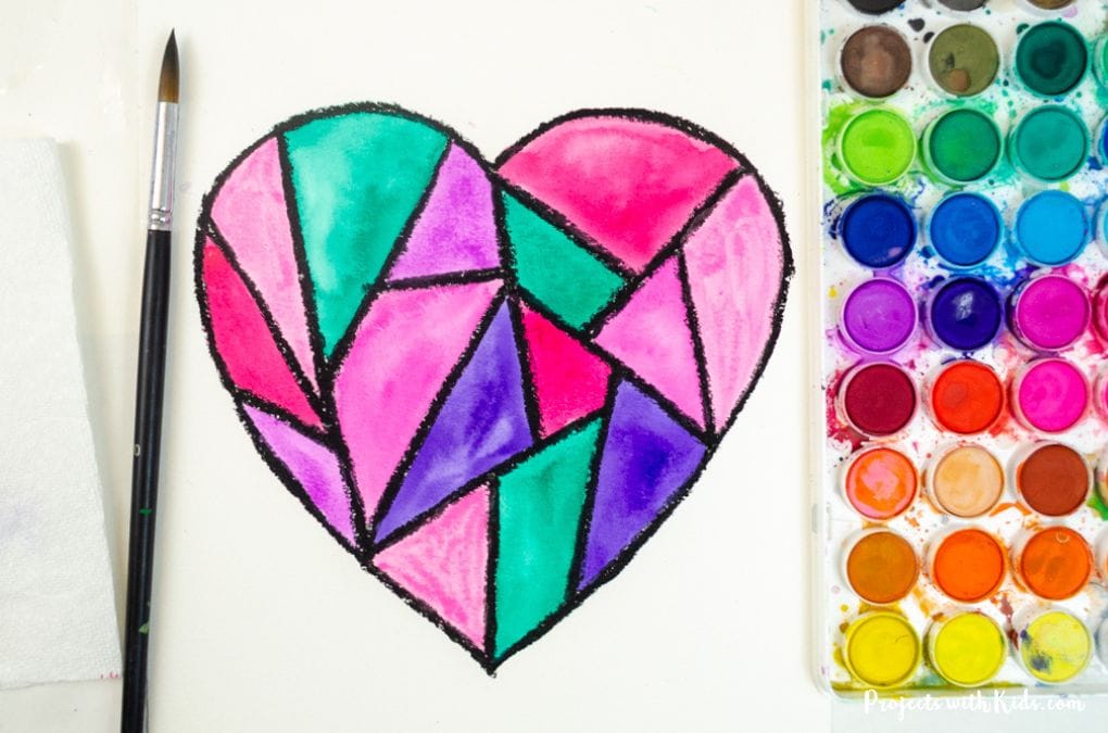 Painting a heart with geometric shapes using watercolor paint.