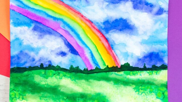 Watercolor rainbow painting idea for kids. Rainbow in a stormy sky with grass.