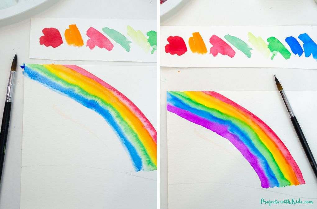 Painting a rainbow in a sky with watercolor paint.