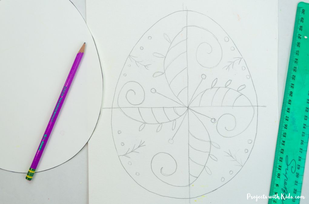 Drawing designs on an Easter egg template to make Pysanky, Ukrainian Easter egg painting for kids.
