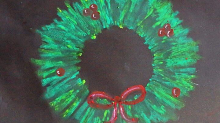 Oil pastel Christmas wreath on black paper art project idea for kids